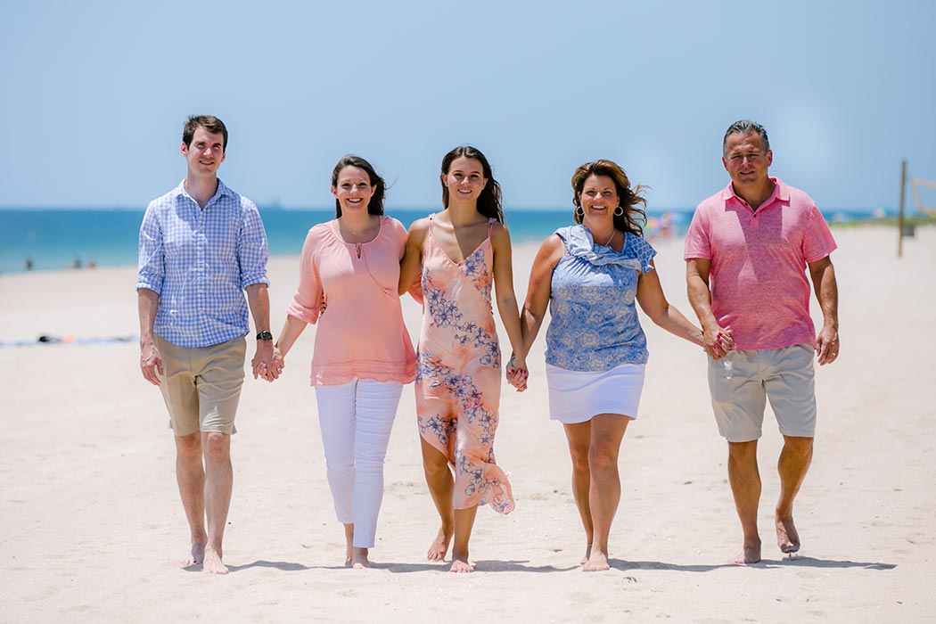 family walking on the beach during gender reveal photoshoot