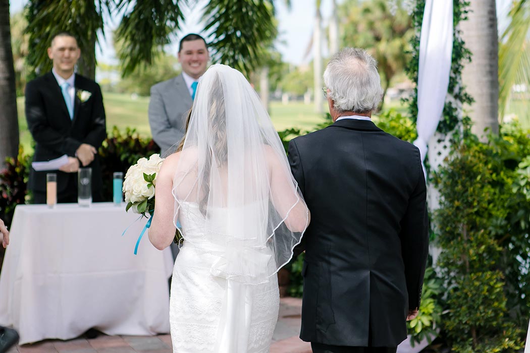 bride walks down aisle with her father at giuseppe's in pompano beach