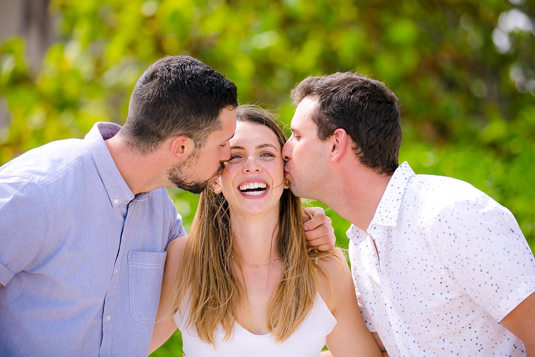 photo of brothers kissing sister on the beach