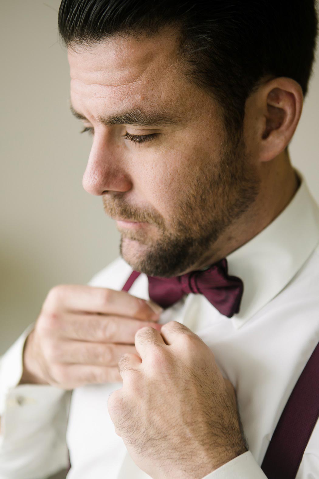 groom getting ready for wedding at biltmore hotel miami | groom red bow tie and suspenders