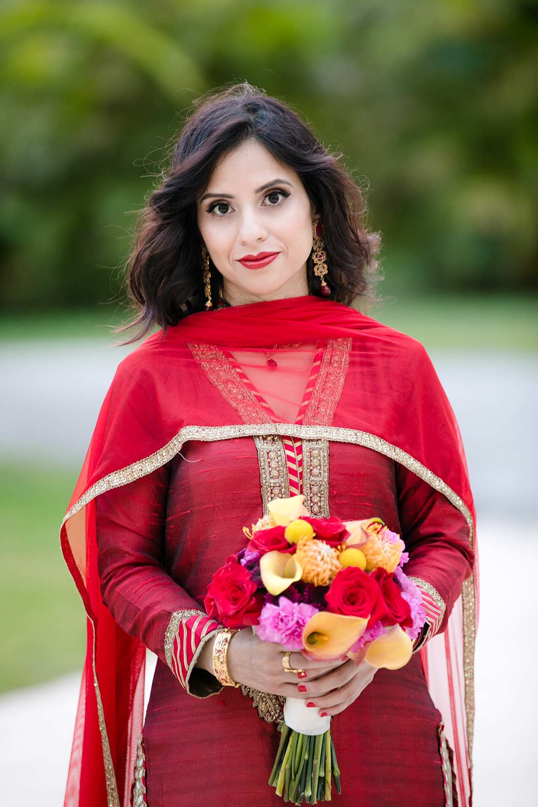 modern wedding bouquet for indian brides | indian bride wears red and gold sari