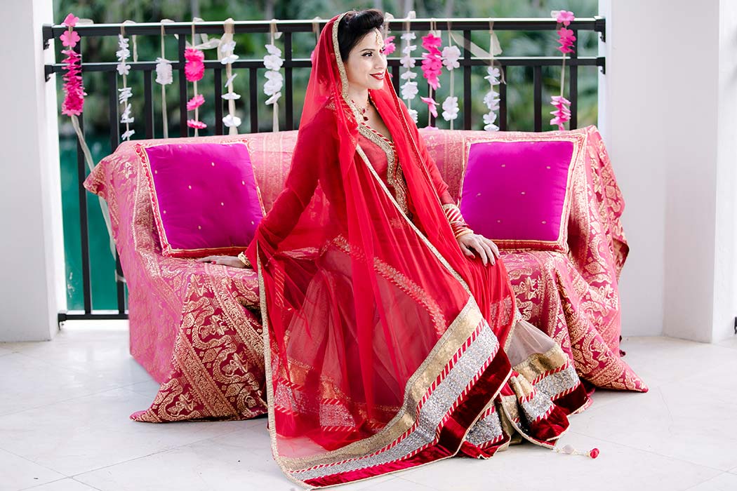 indian bride wearing red and gold sari poses for indian wedding styled photoshoot