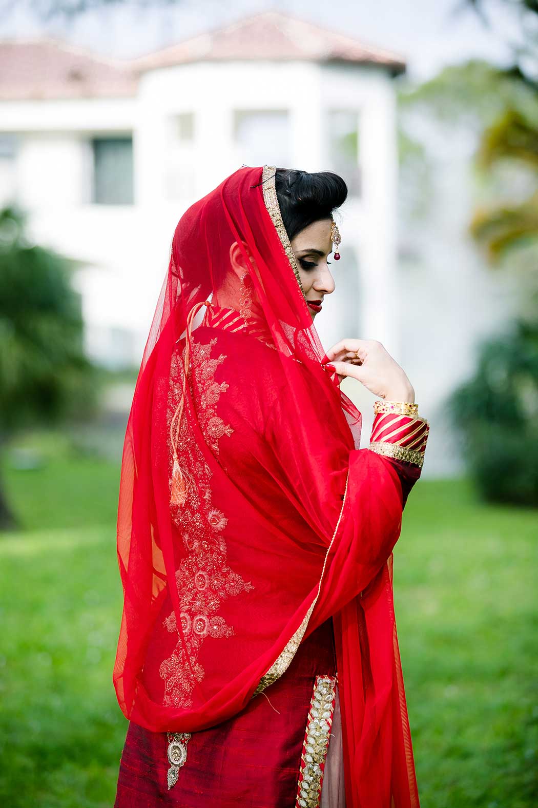 indian bride wearing red and gold traditional sari