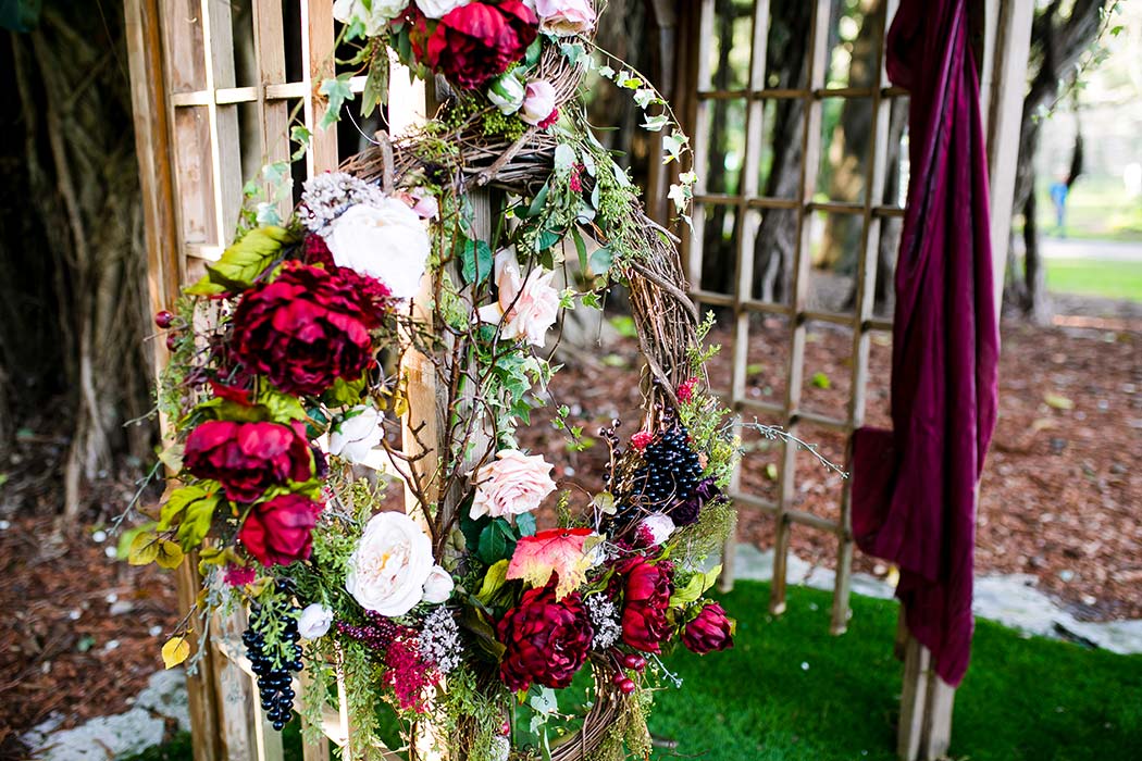 red and purple handmade floral wedding arch for rustic wedding