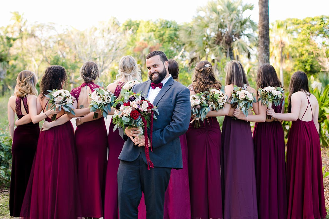 groomsmen poses with bridesmaids at flamingo gardens