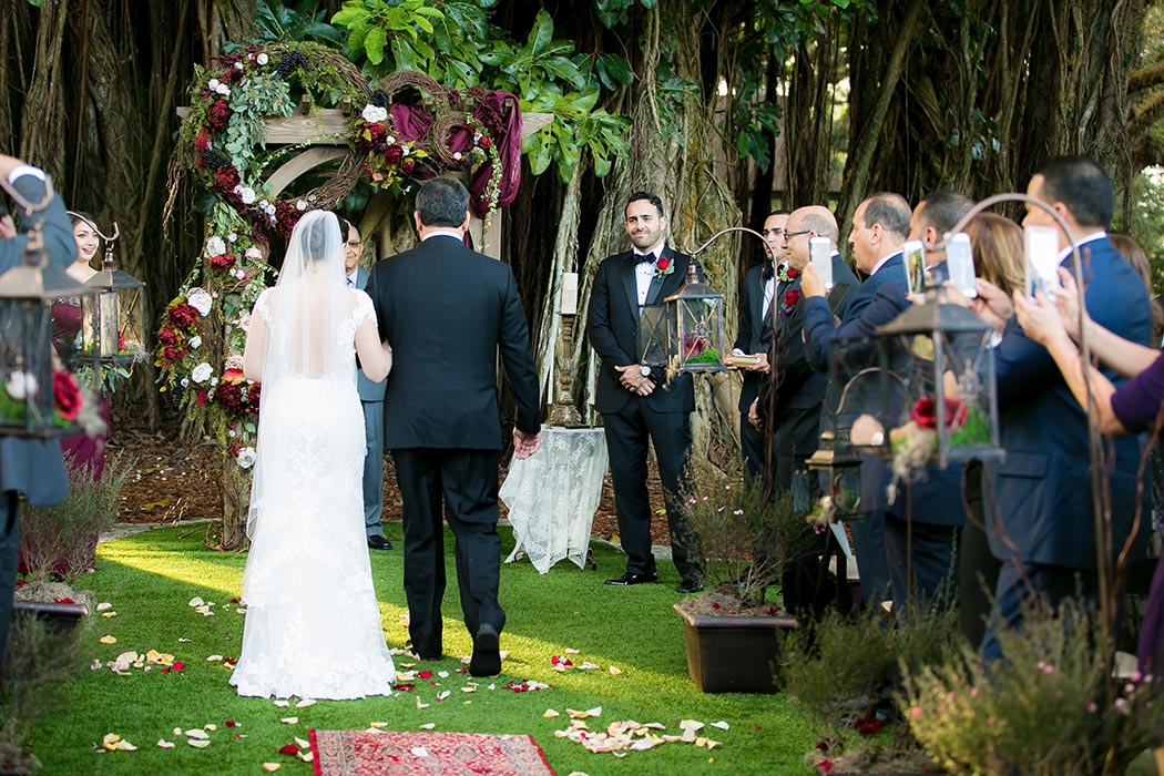 bride walks down aisle at flamingo gardens wedding