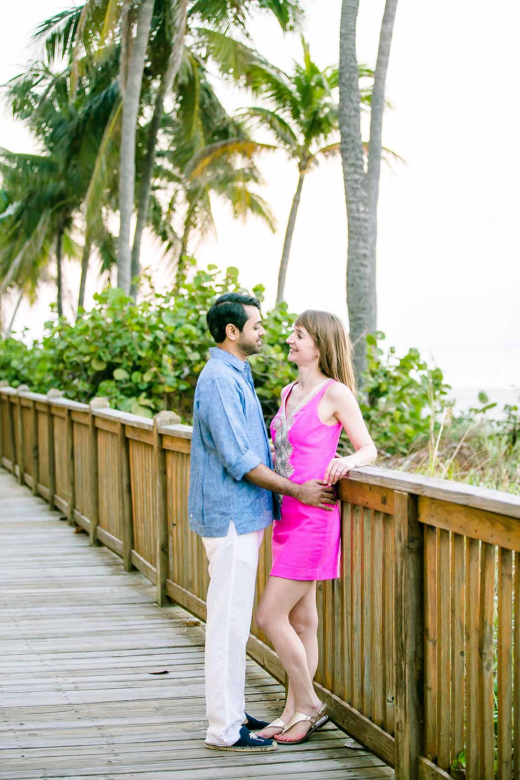 engaged couple walk on wooden walkway | fort lauderdale beach engagement | beach engagement photography fort lauderdale | beach walkway photoshoot in south florida