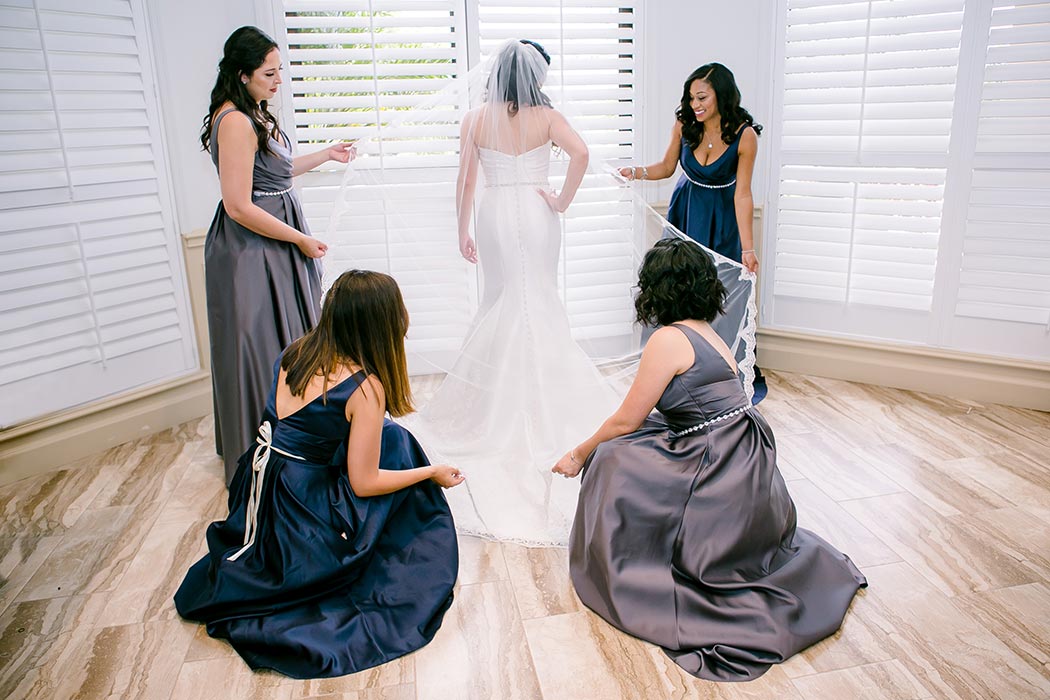 bridesmaids helping bride get ready | unique photo of bridesmaids helping bride dress | modern wedding at breakers west country club