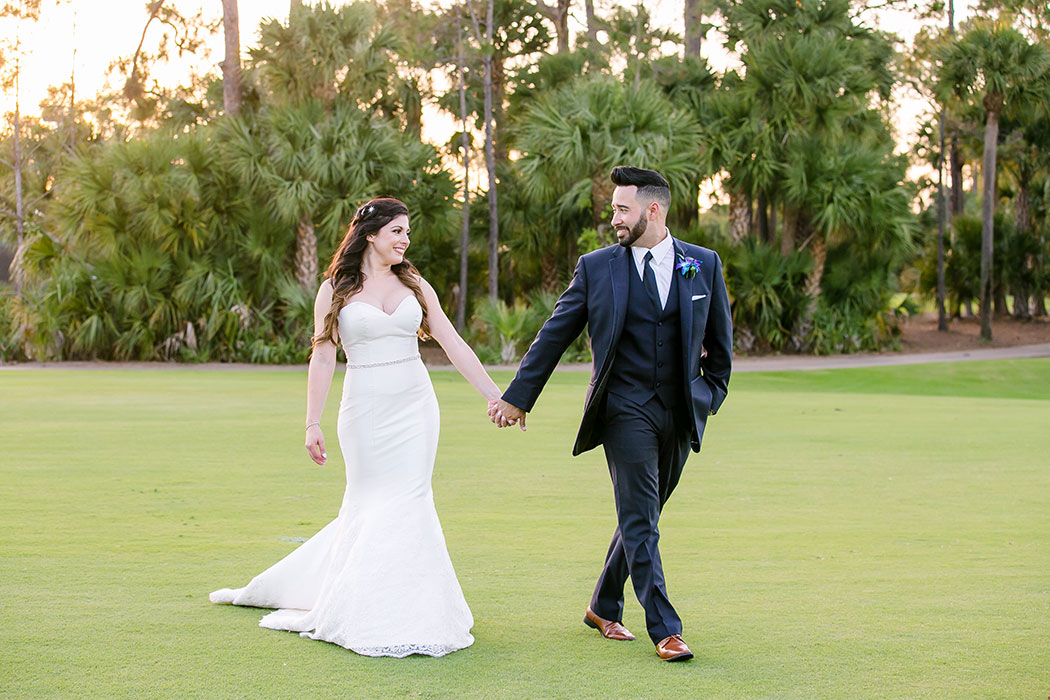 bride and groom holding hands walking across golf course | breakers west country club wedding | wedding in fort lauderdale