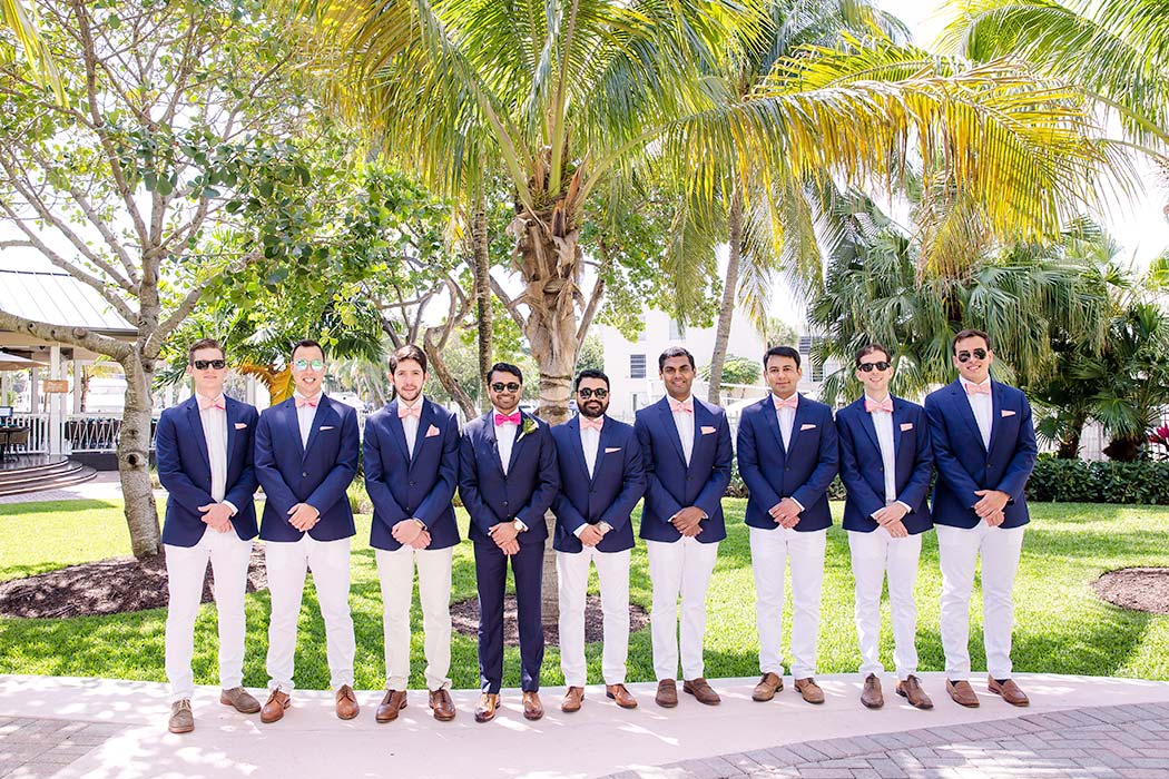 indian groom in navy suit and pink bow tie | unique groomsmen pose | indian groom and his groomsmen photograph