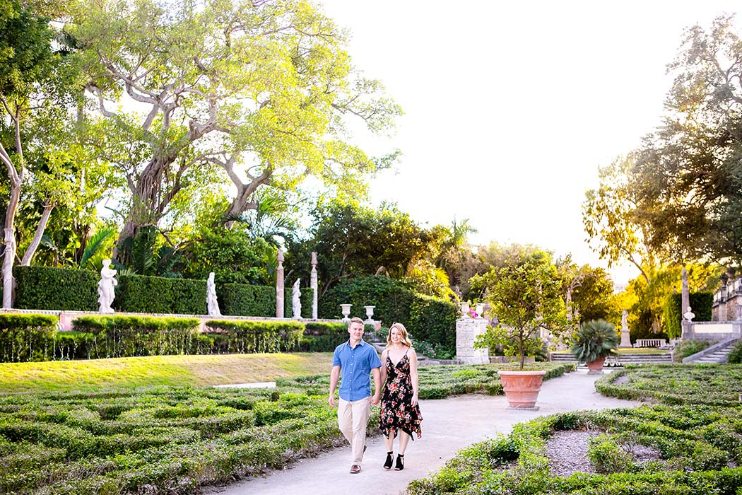 engaged couple walking through vizcaya gardens during photoshoot