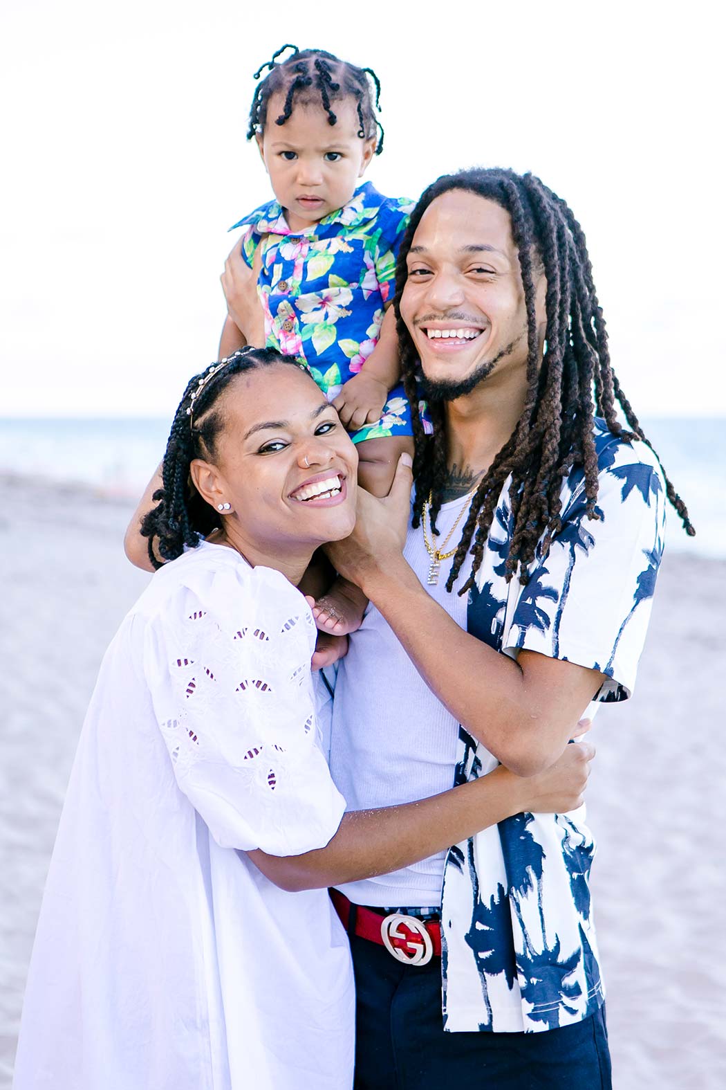 family hugging on the beach during a photography session | fort lauderale family photography | black family pose for family photos | black family beach photoshoot