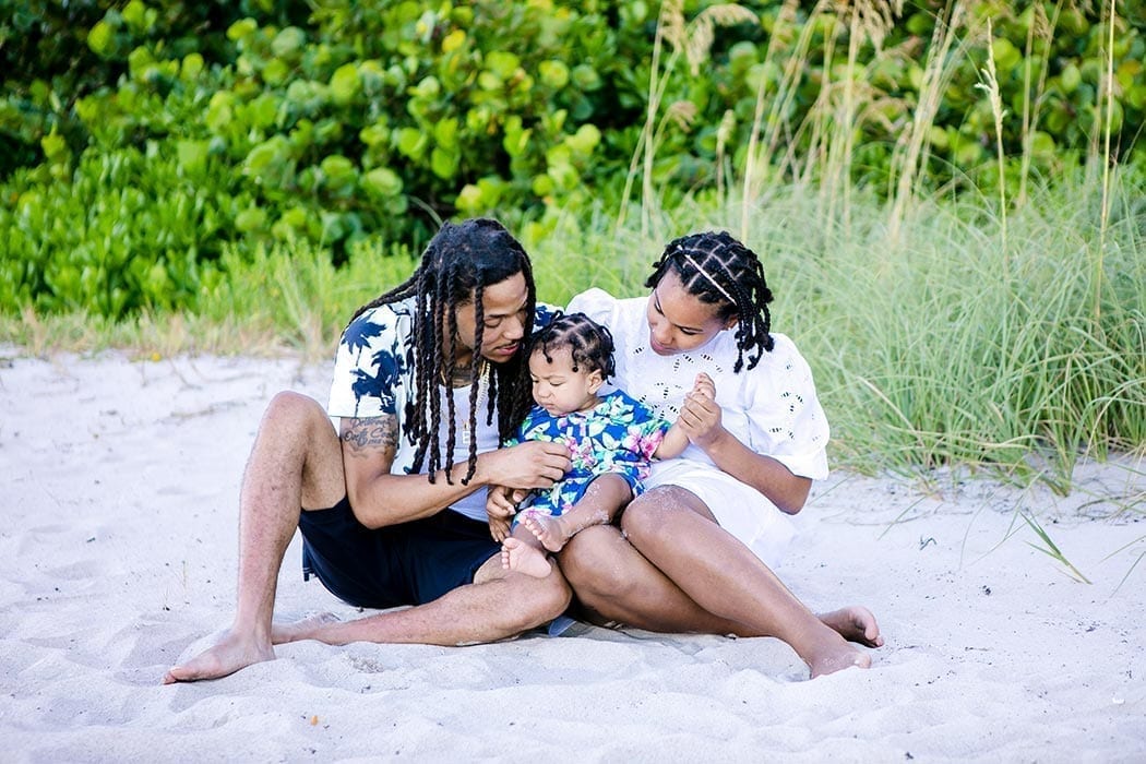 family portrait session on fort lauderdale beach | family of three sit for beach photos | fort lauderdale family photographer