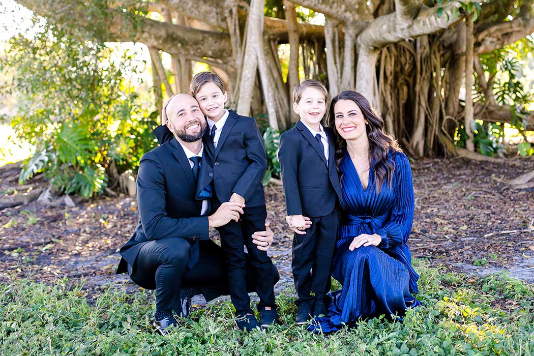 family of 4 taking formal photographs in fort lauderdale park | family dressed up for photographs | beautiful family photographs in robbins preserve | formal family photography fort lauderdale 