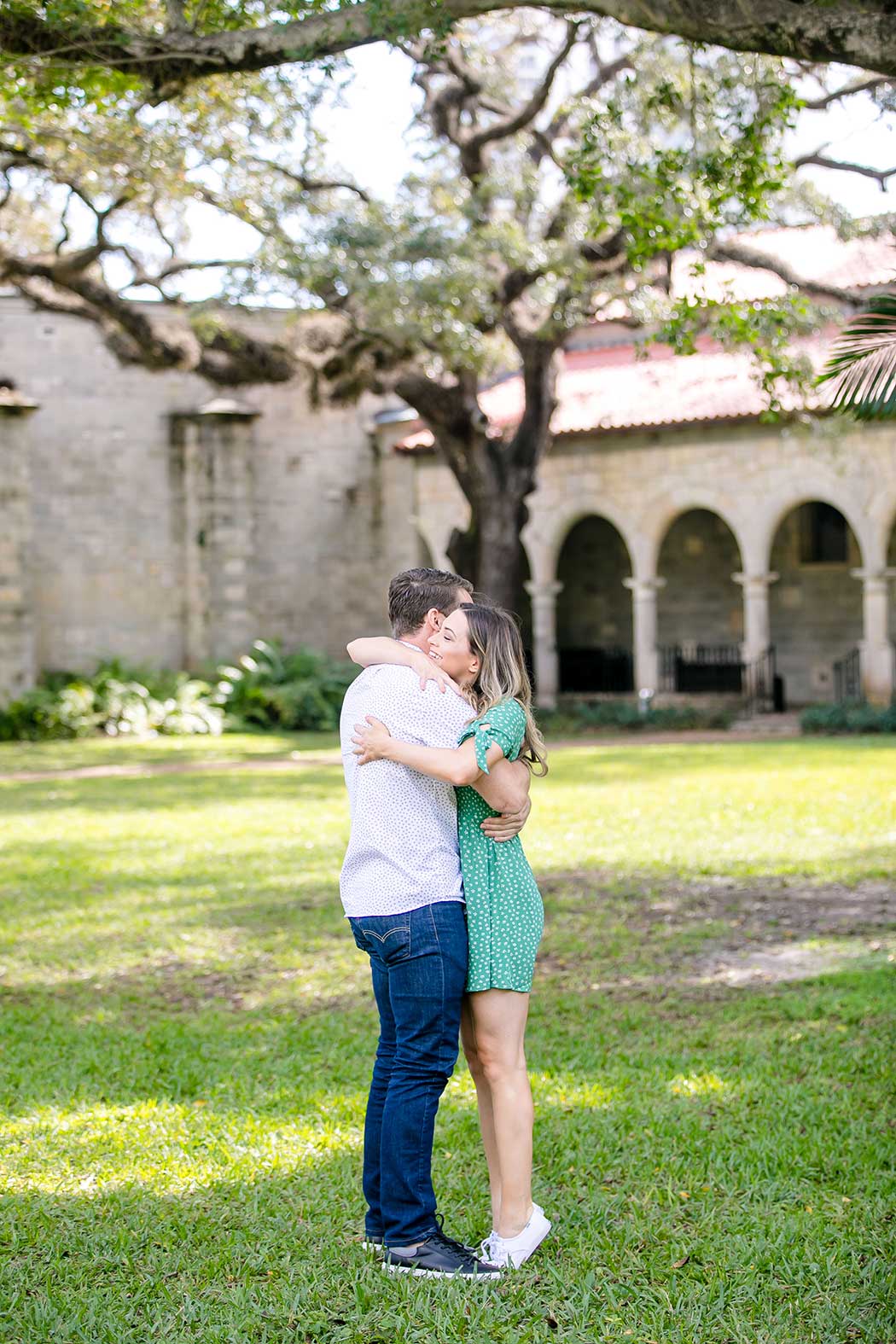girl hugging boyfriend after surprise proposal | wedding proposal at ancient spanish monastery | engagement photographer fort lauderdale | ancient spanish monastery proposal photographer