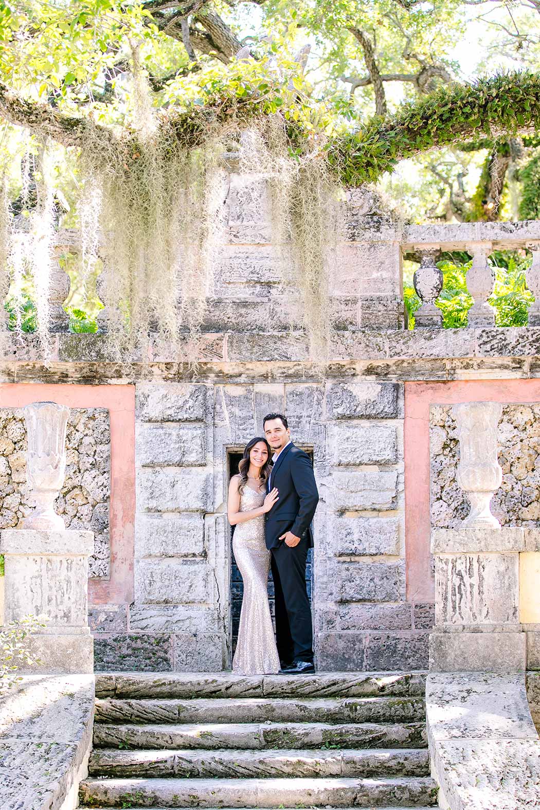 couple pose for engagement photoshoot at vizcaya museum miami | long red dress for engagement