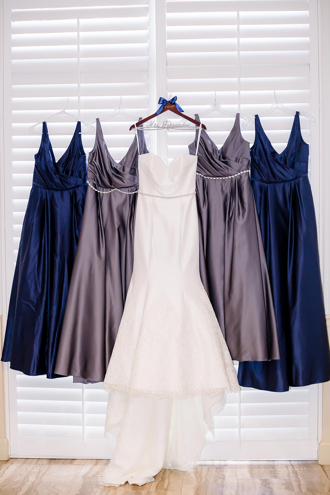 wedding dress detail photograph | hanging wedding dress and bridesmaids dress for wedding photography | alexander couture bridal dress