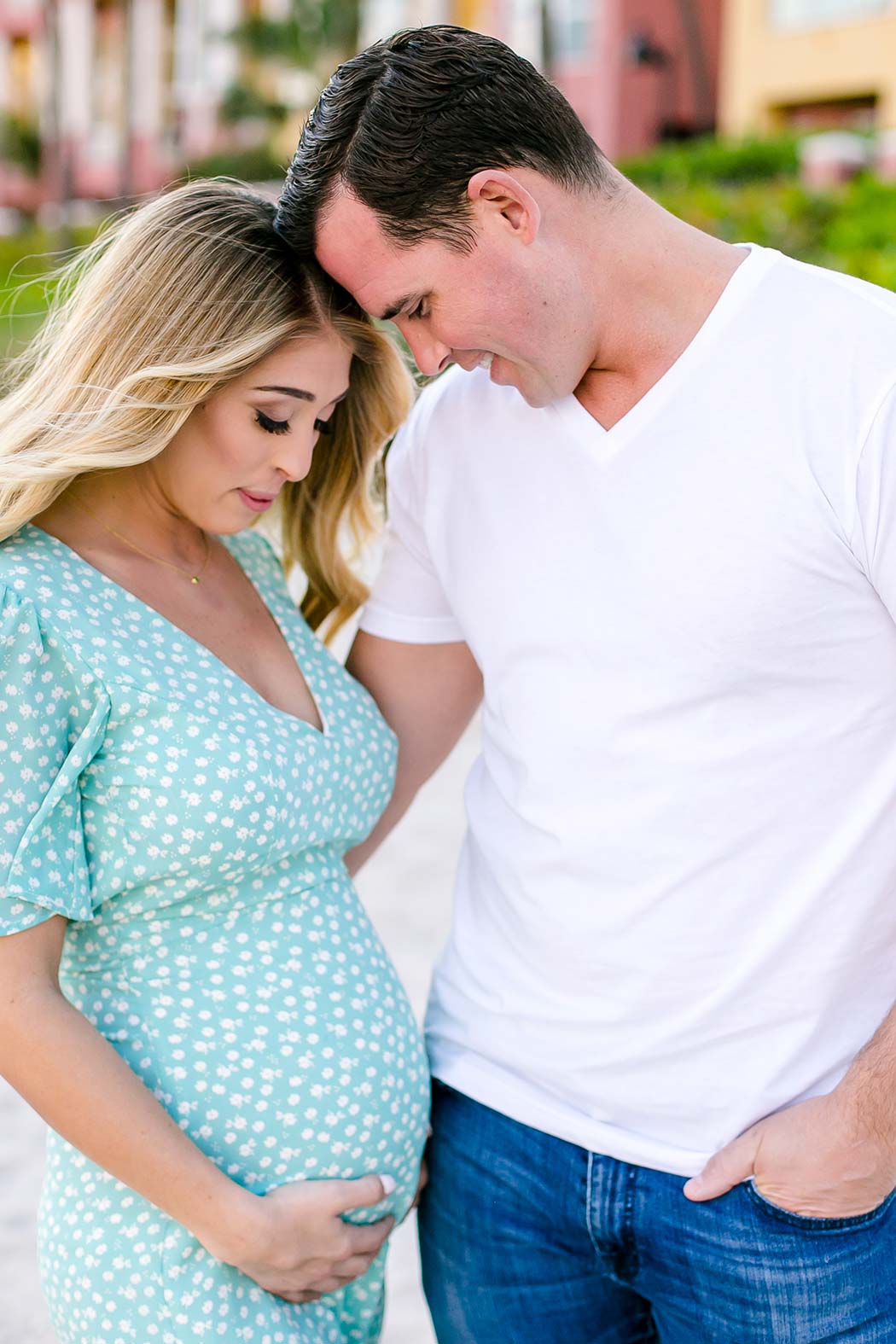 husband and wife pose for maternity photos | expectant mother holds belly in photoshoot | maternity photographer south florida