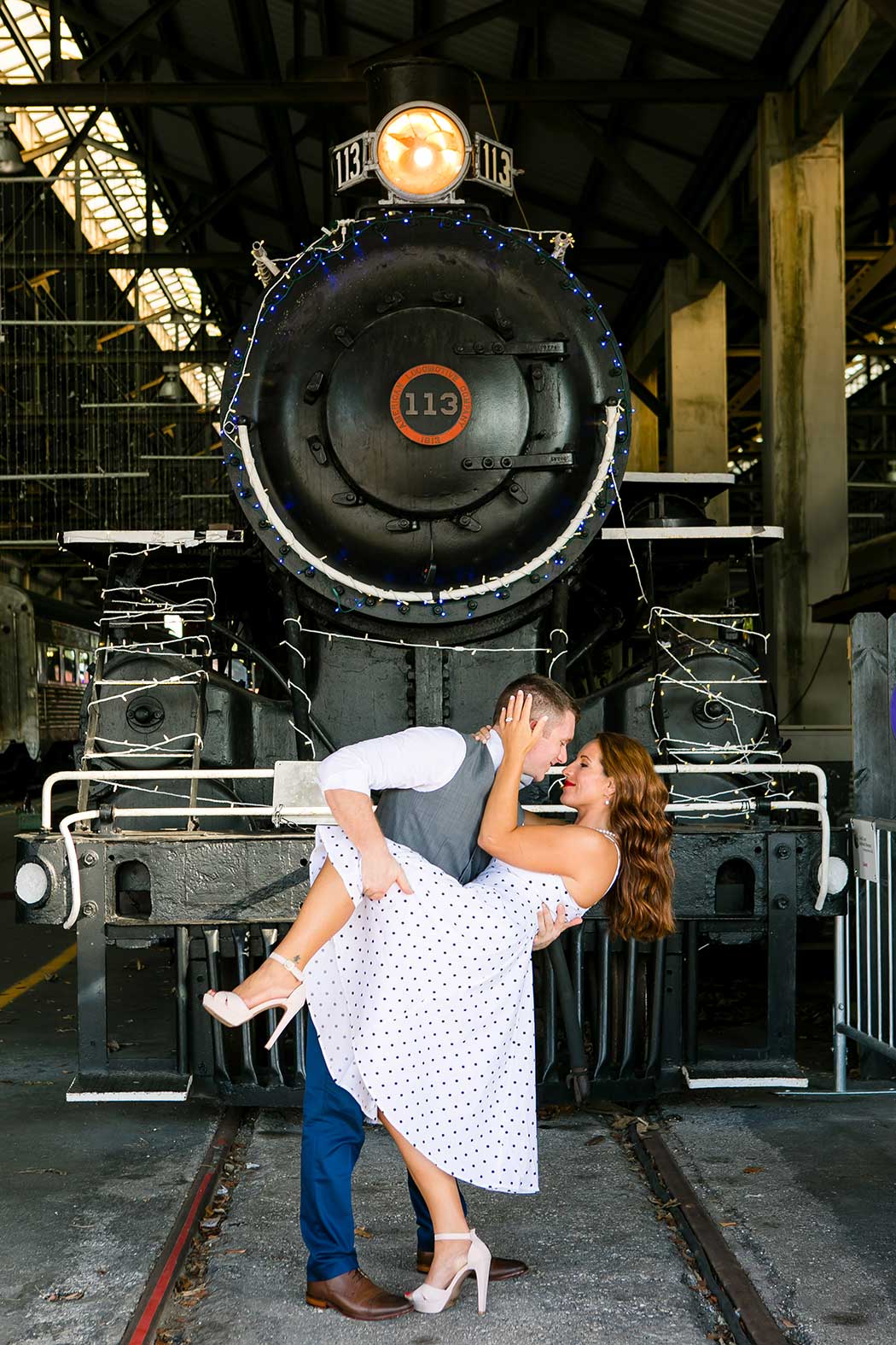 boy dipping girl for engagement photoshoot | boy dips girl picture | engagement session on railroad