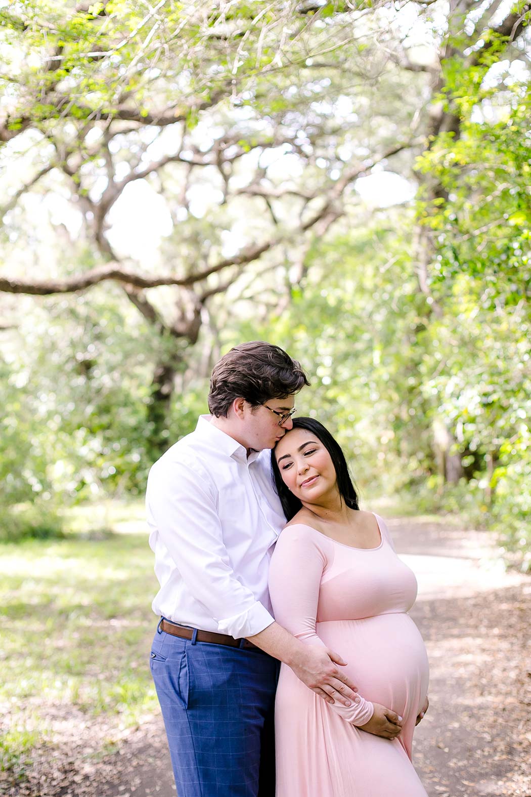 mother to be photography | pink maternity dress | girl poses in park for maternity session | unique pose for maternity photography | tree tops park maternity photographs