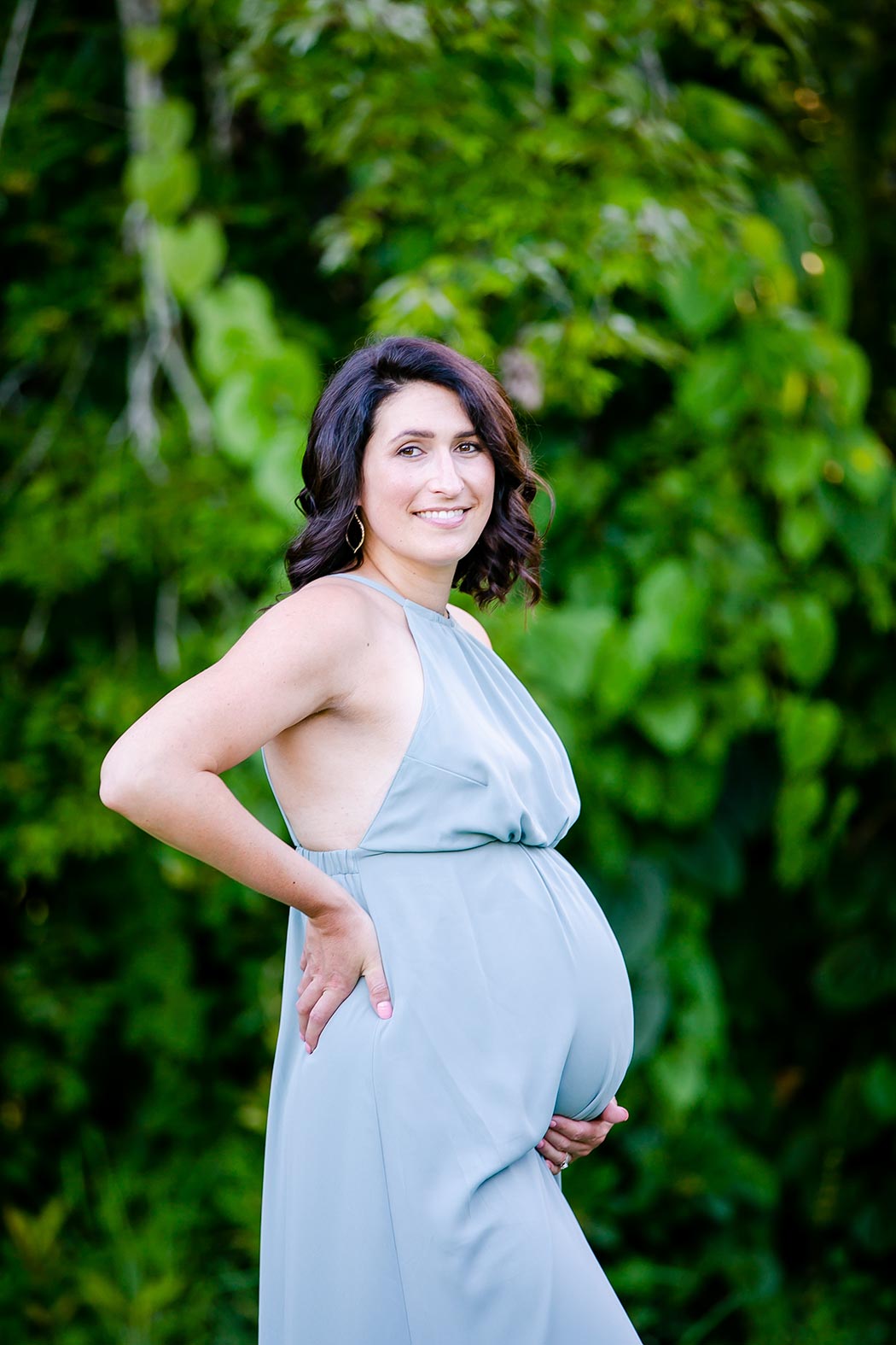 maternity poses for expectant mothers | maternity photography holding belly in long green maternity dress