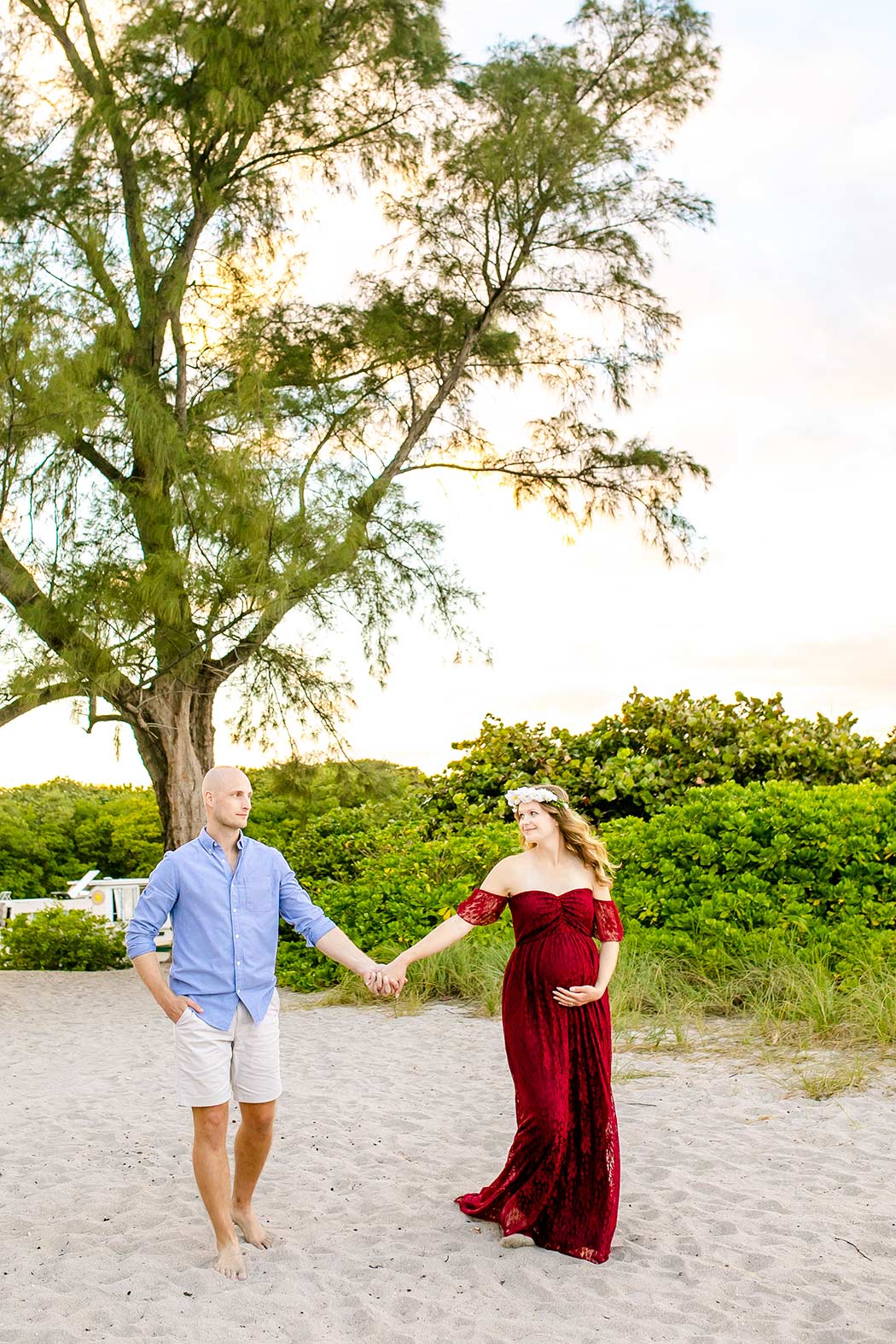 beach maternity photo ideas | couple hold hands for maternity photoshoot | walking pose on dania beach with family photographert 