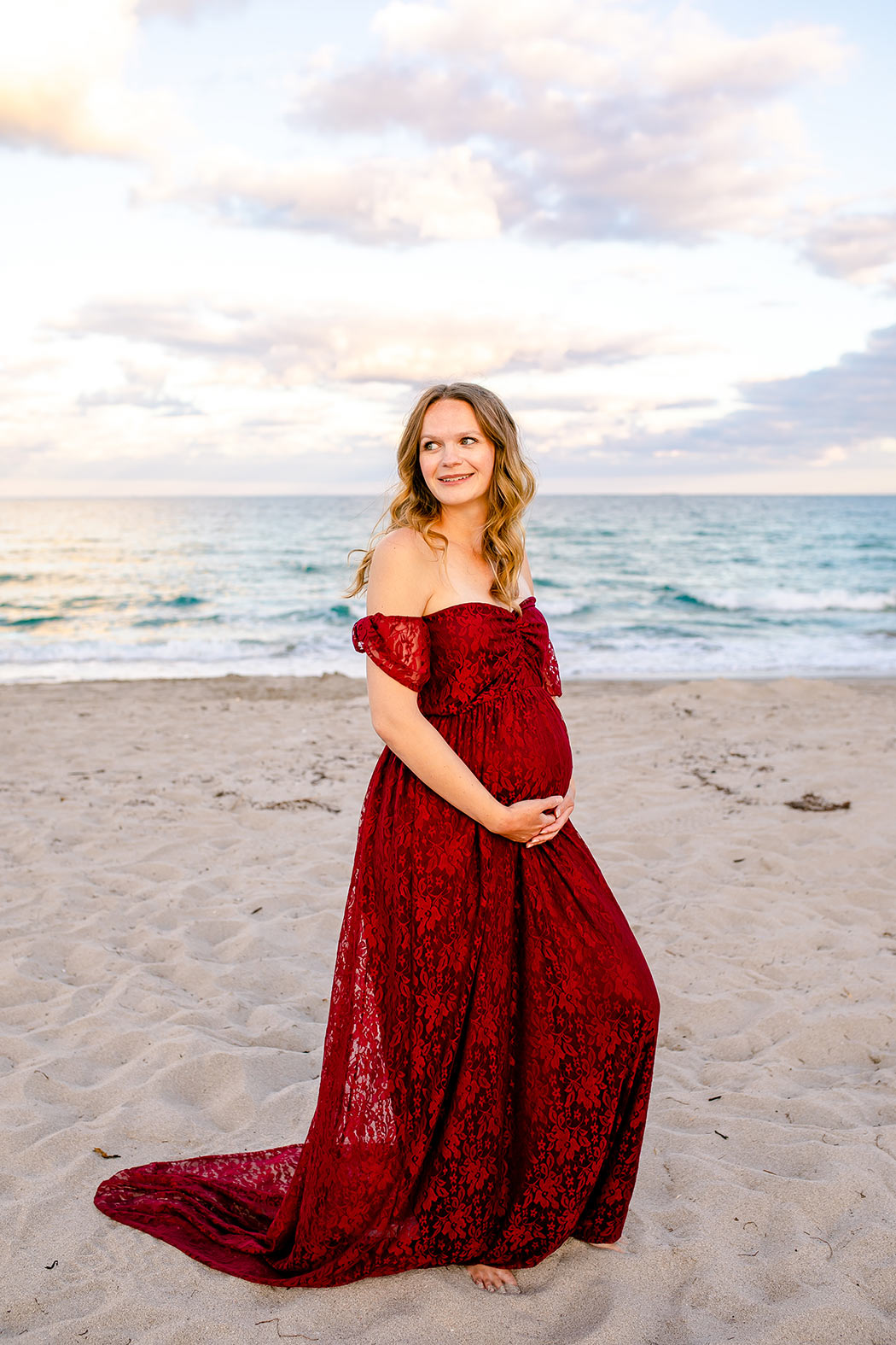 girl poses for beach maternity photos | expectant mother holds belly in photoshoot | maternity photographer south florida | maternity photography dania beach pier south florida