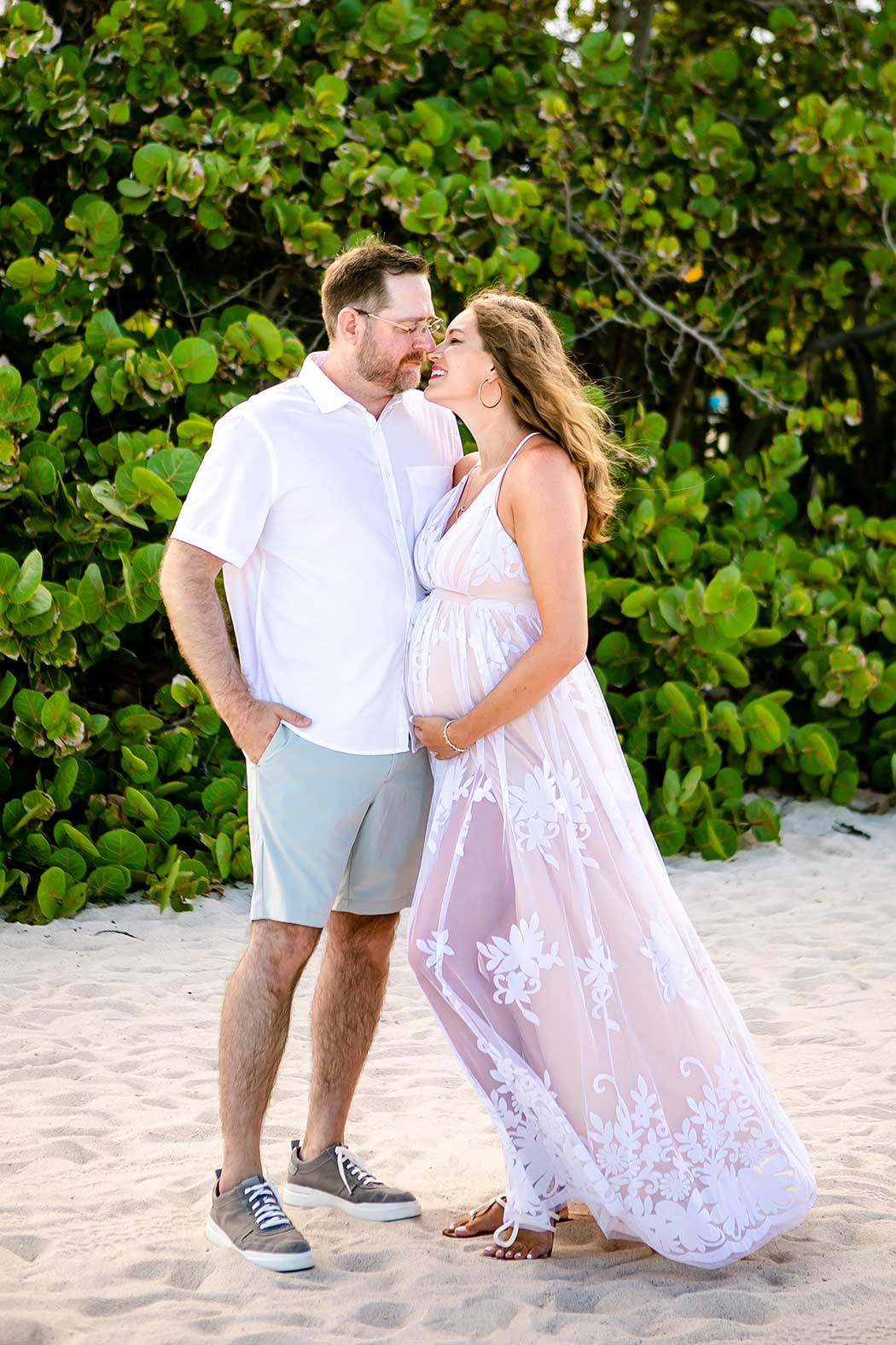 couple pose for beach maternity photo