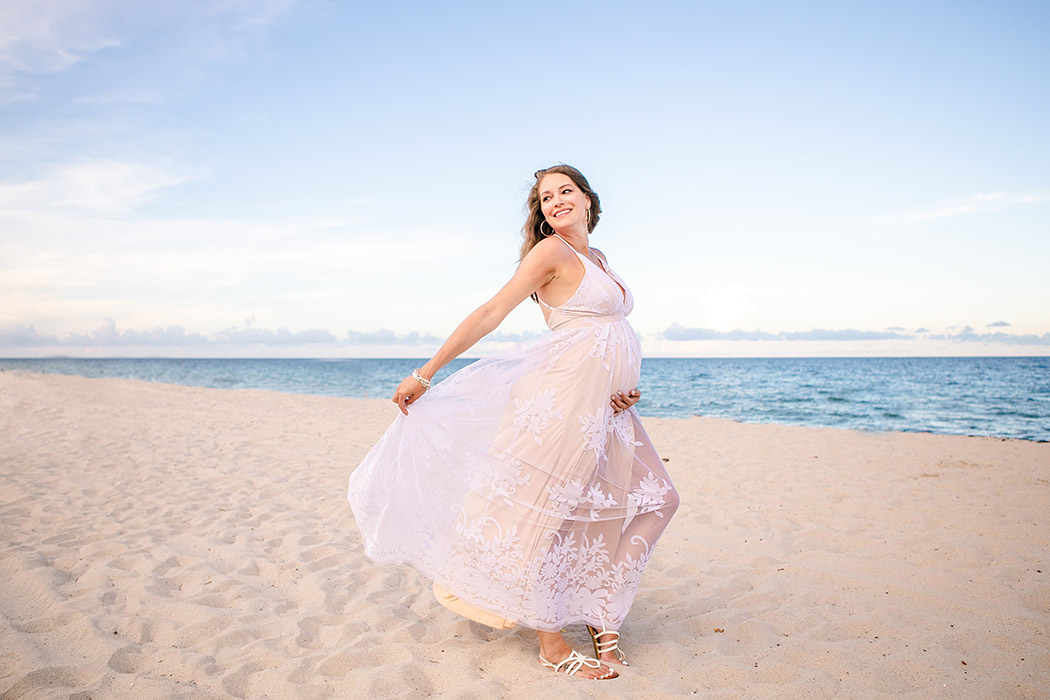 lady poses during beach maternity session in fort lauderdale