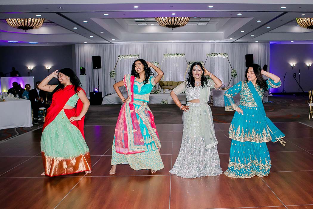indian bride dances with friends at wedding | indian bride wears green sequenced gown 