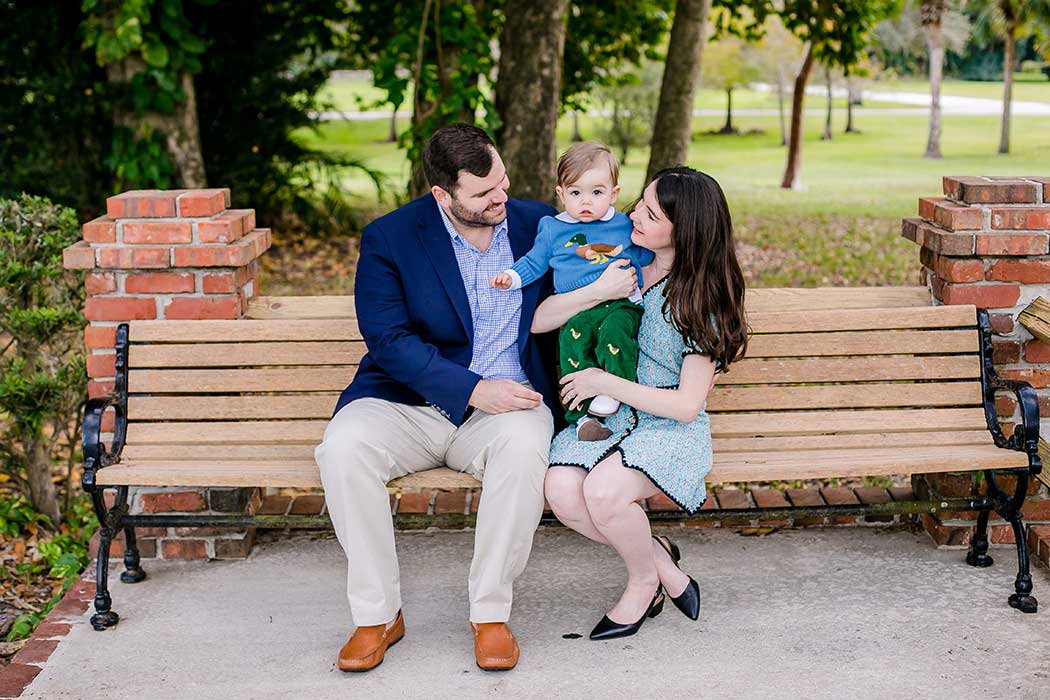 Family of three enjoying a family photoshoot on a bench in robbins preserve