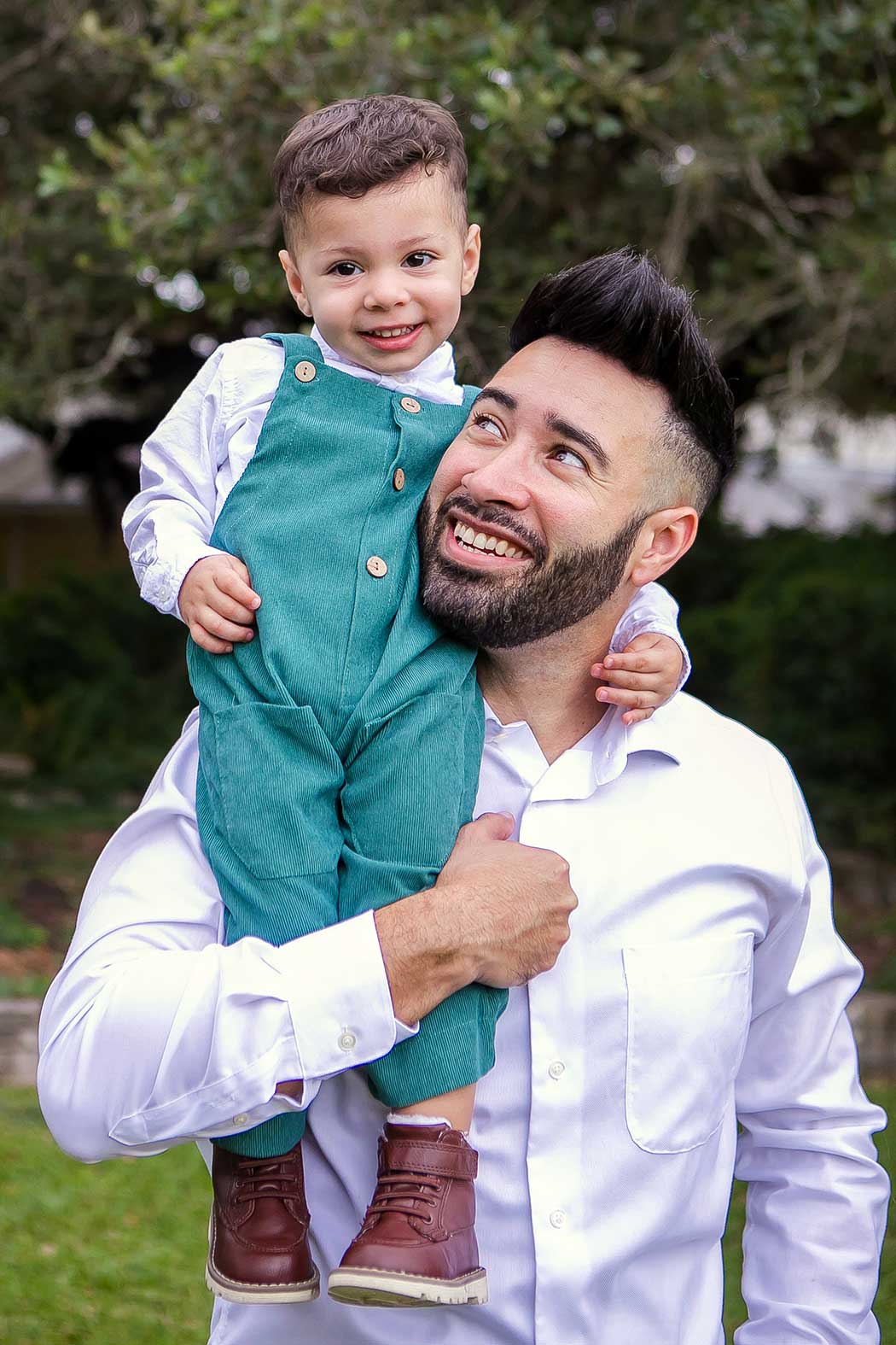 dad holds son on his shoulders for a family photoshoot