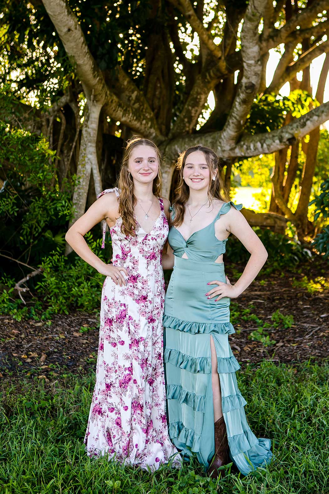 two sisters with hands on hips smiling at the camera