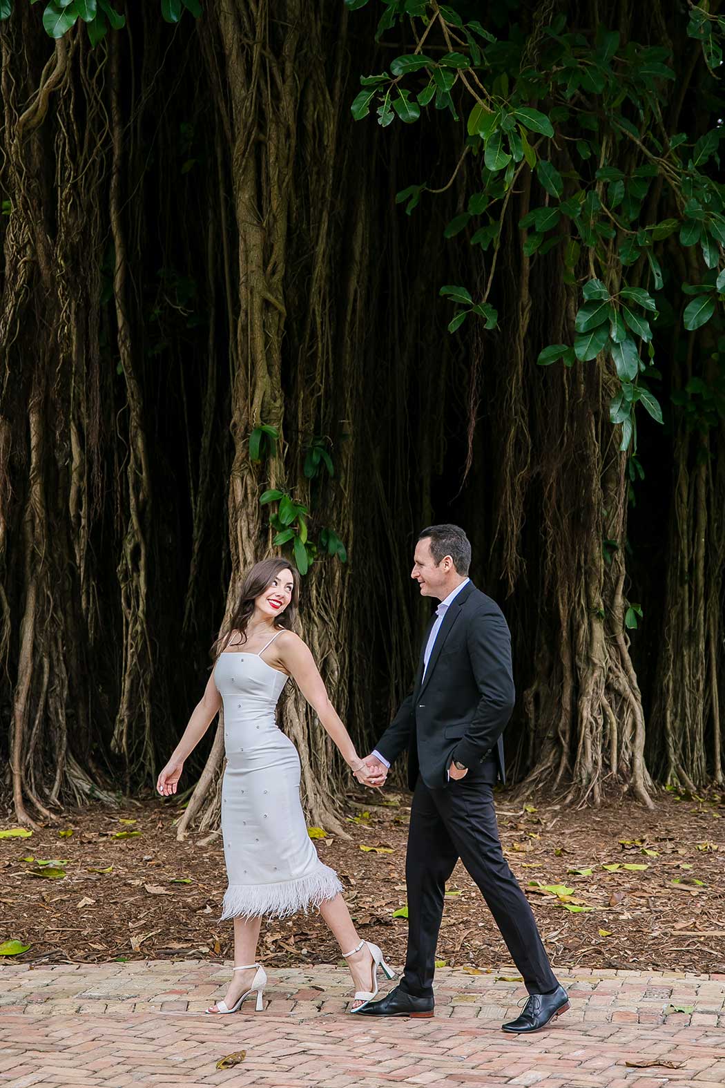 Engaged couple having a fun photoshoot at Flamingo Gardens, South Florida, with a tropical backdrop