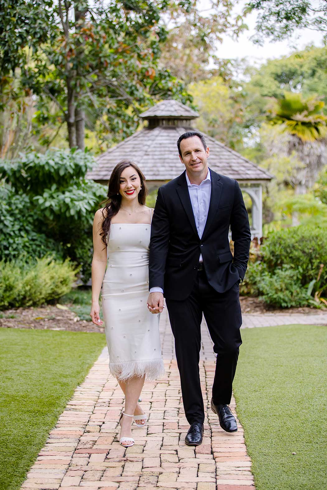 Outdoor couples photoshoot in Flamingo Gardens, featuring a couple surrounded by palm trees and colorful flowers