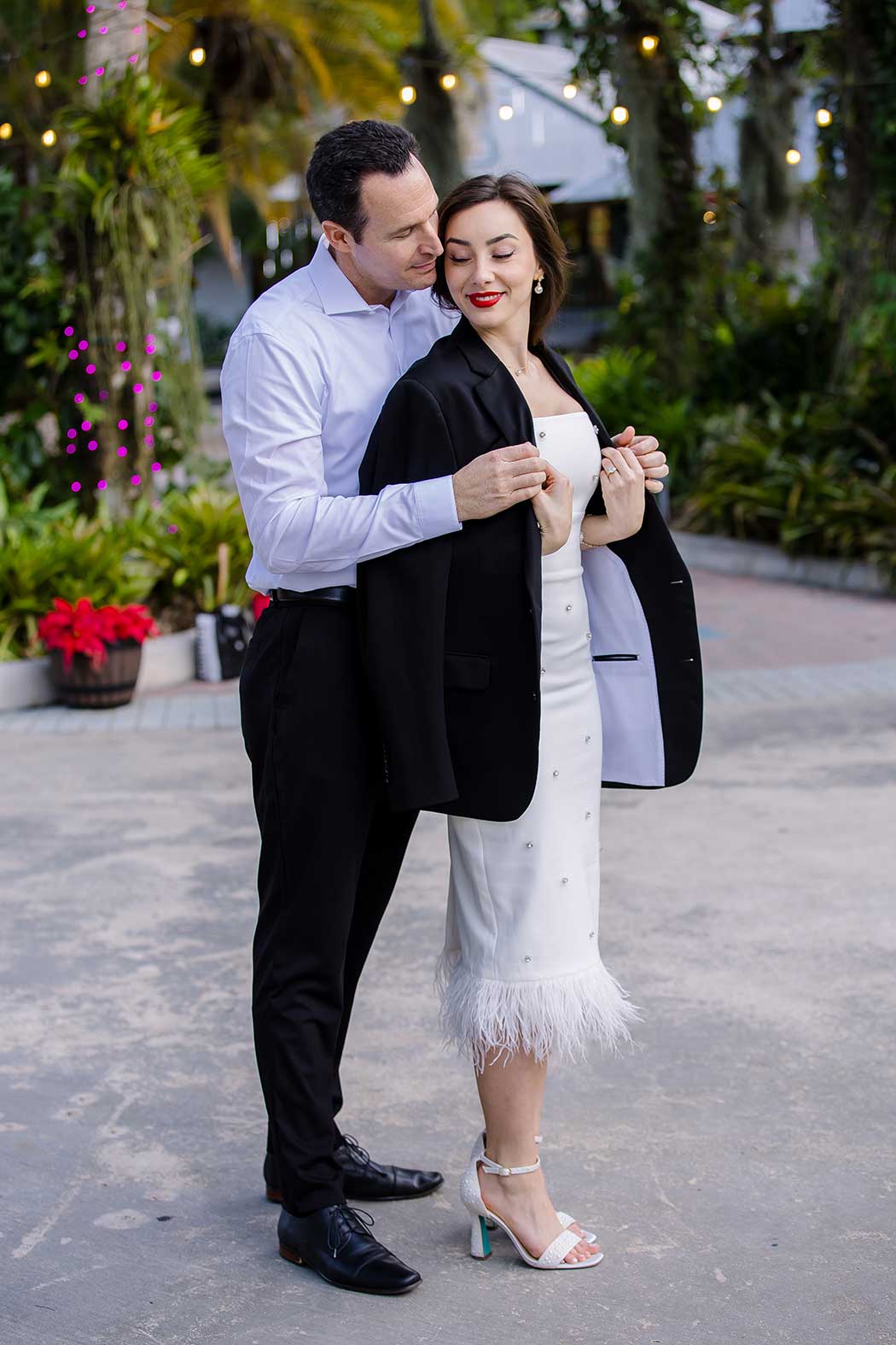 Man gives his wife jacket at flamingo gardens during engagement photoshoot