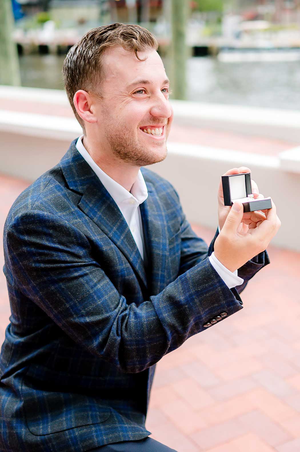 Love in His Hands Man holding out engagement ring during surprise proposal at Fort Lauderdale Riverwalk