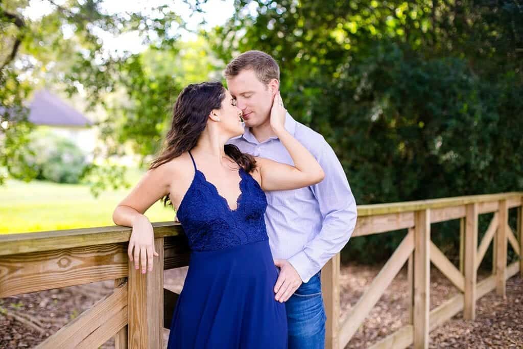 A couple shares a sweet moment during their Green Meadows Preserve engagement session in Marietta. The photo features golden sunlight, natural greenery, and genuine smiles that capture their love and connection in a serene outdoor setting.