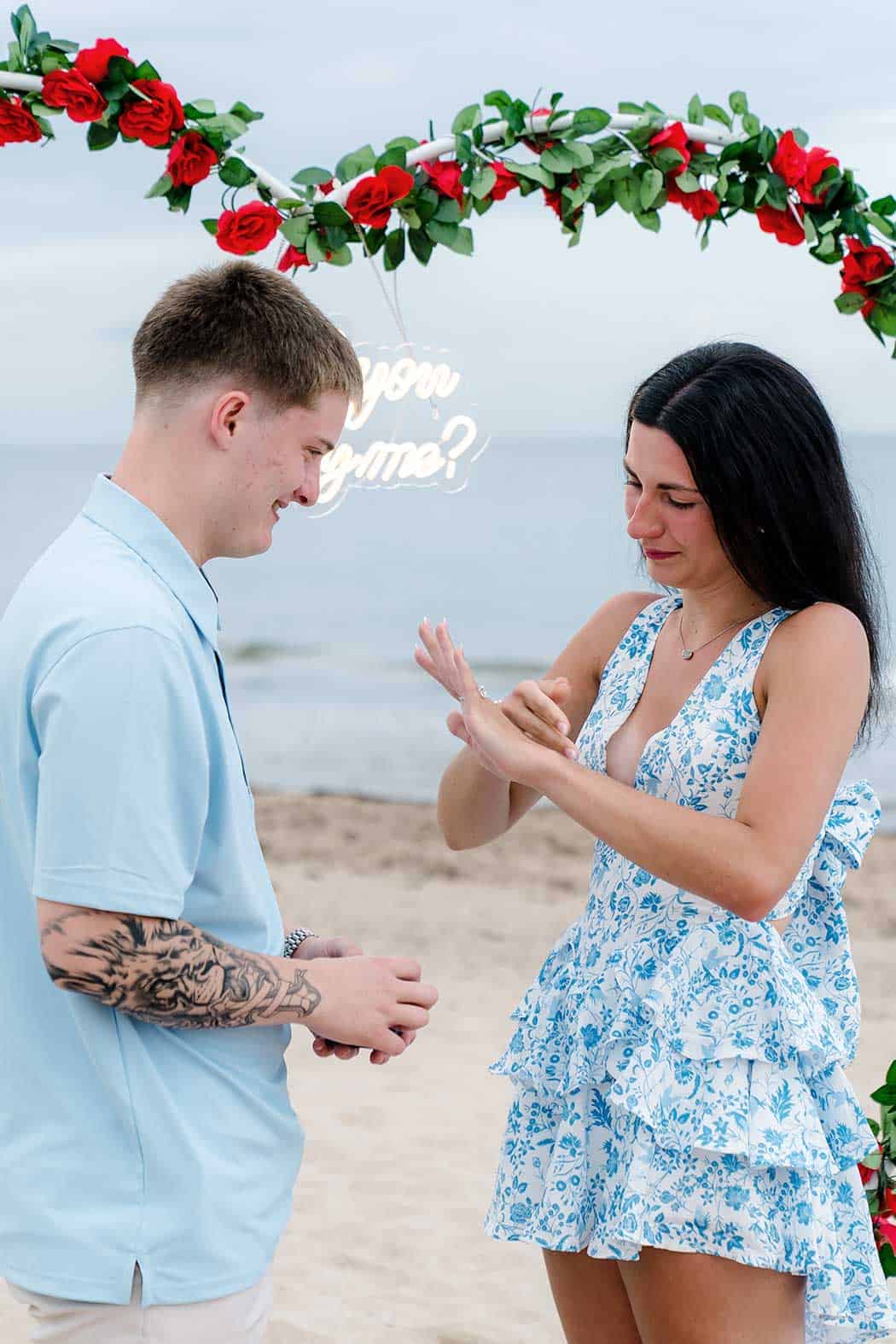 placing the engagement ring on her finger after proposing on Fort Lauderdale Beach
