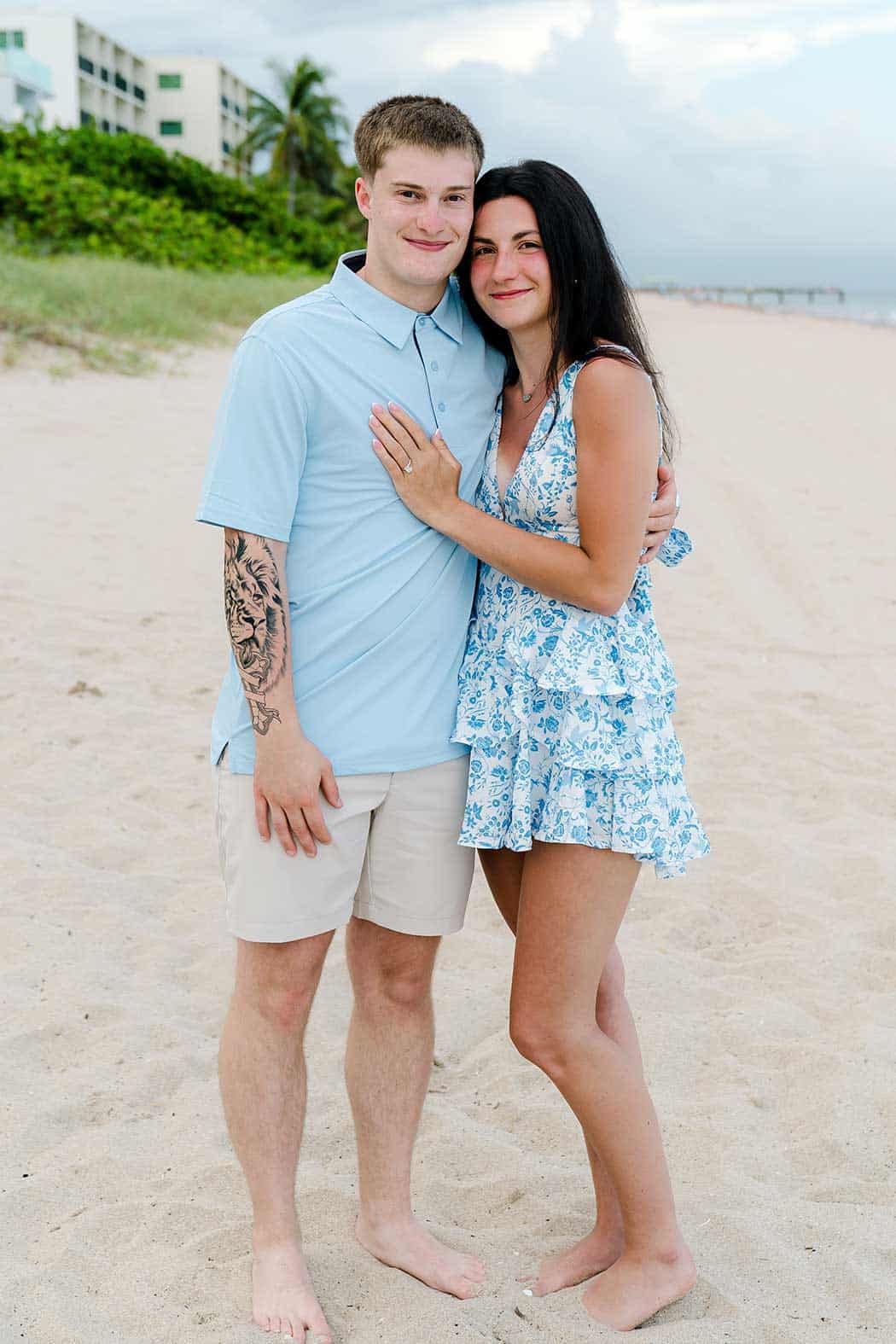 Newly engaged couple smiling together after a surprise beach proposal
